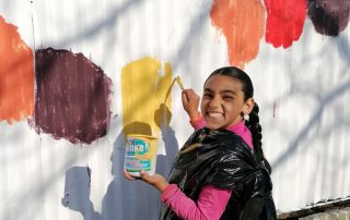 06_2021-04-29-Kunterbuntes-BuKi-Haus—Streichen-des-Zaun-mit-Kindern_Ersebeth_Dschangün BuKi-Haus kunterbunt